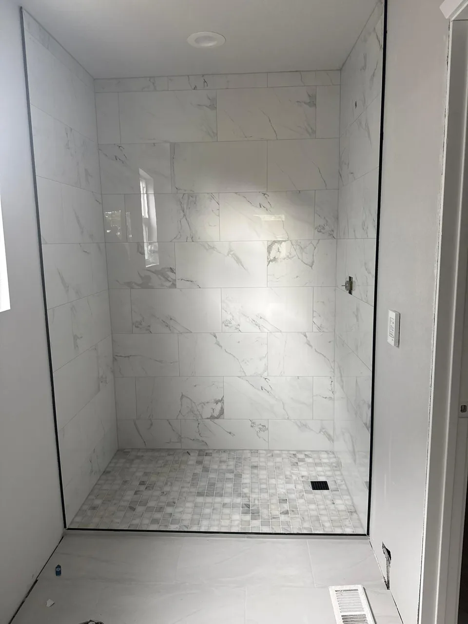 White tile shower and bathroom floor