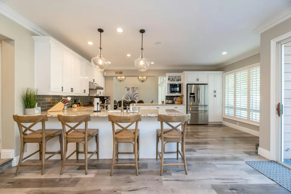 Light plank flooring across an open kitchen